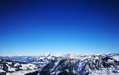 Scenic view of snowcapped mountains against clear blue sky