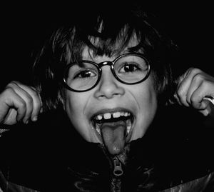 Close-up portrait of young boy sticking out tongue