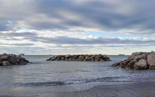 Rocks on sea shore against sky