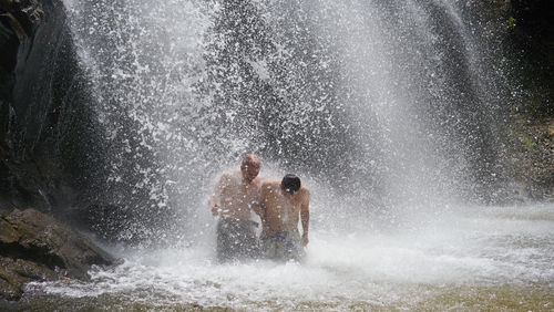 Two men splashing water