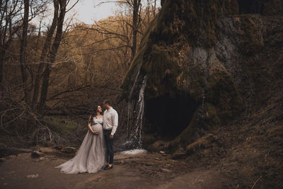 Rear view of woman standing in forest