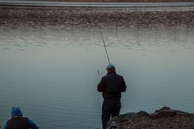 Rear view of man fishing in sea