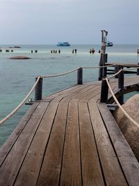 Wooden pier over sea against sky