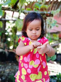 Little girl is enjoying the morning air by playing in the garden in front of the house
