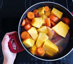 High angle view of hand holding fruits in plate