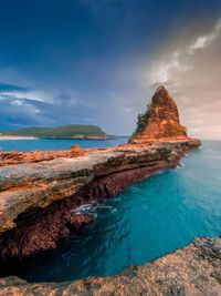 Scenic view of rocks in sea against sky
