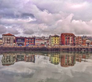 Reflection of buildings in lake against sky