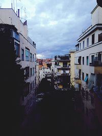 Buildings in city against cloudy sky