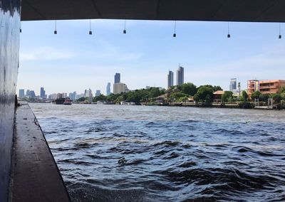 City buildings by sea against sky