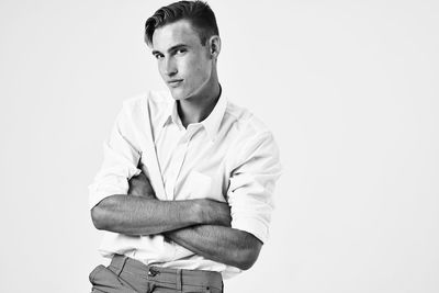 Portrait of young man standing against white background