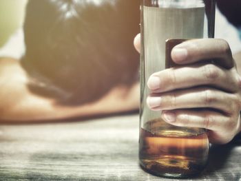 Close-up of man drinking glass on table