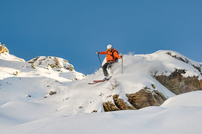 Free.rider skier descends between rocks on the italian alps