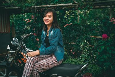 Portrait of smiling young woman sitting outdoors