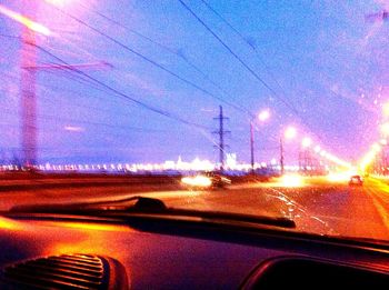 Cars on road against sky at night