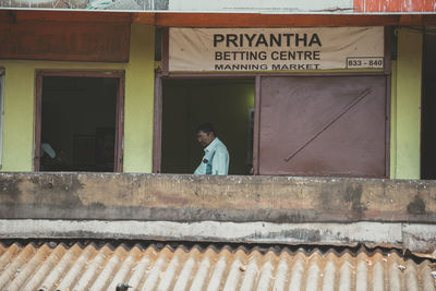 Full length of man standing by sign