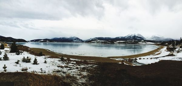 Panoramic view of frozen lake against sky