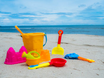 Toy on beach by sea against sky