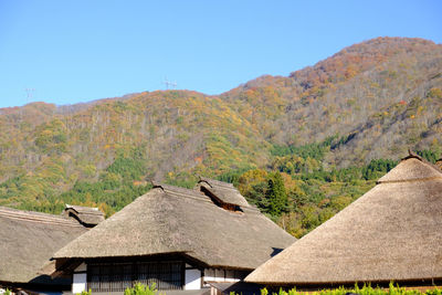 Scenic view of village by mountains against clear sky