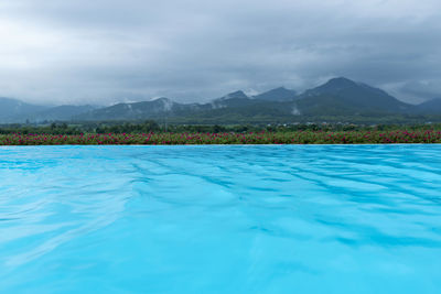 Swimming pool by sea against sky