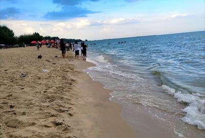 People on beach against sky