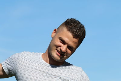 Portrait of young man against clear blue sky