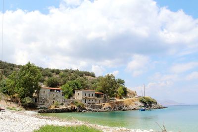 Houses by sea against sky