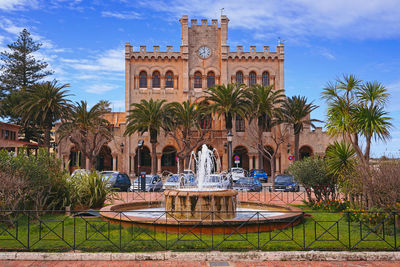 Fountain and trees against buildings in city