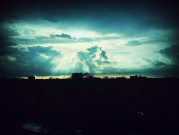 Silhouette of landscape against cloudy sky