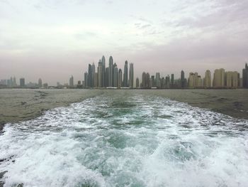 Scenic view of sea and cityscape against sky