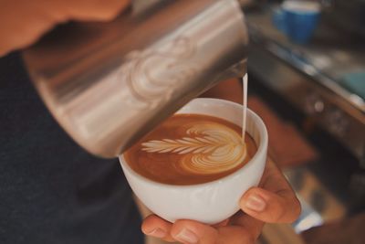 Cropped image of hand holding coffee cup