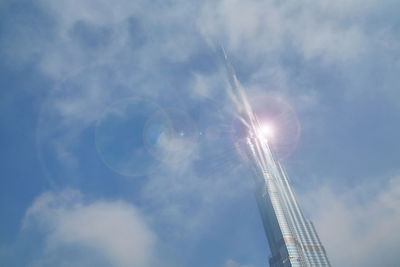 Low angle view of skyscraper against sky on sunny day