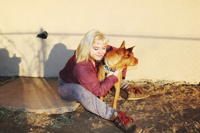Young woman with dog sitting outdoors
