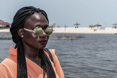 Africa woman with sunglasses from ghana enjoying the sun on a beach in accra.