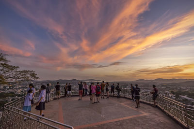 Group of people walking on beach during sunset