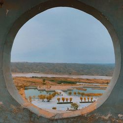 Scenic view of landscape against clear sky seen through window