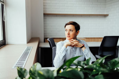 Young woman using mobile phone while sitting at home