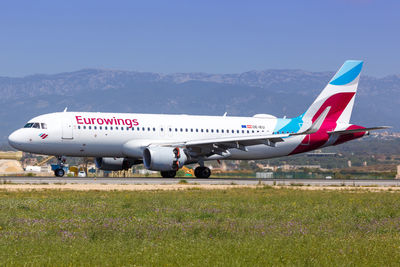 Airplane on runway against sky