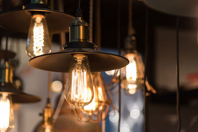 Close-up of illuminated pendant lights hanging in restaurant