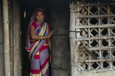 Portrait of indian woman standing  at door of the house