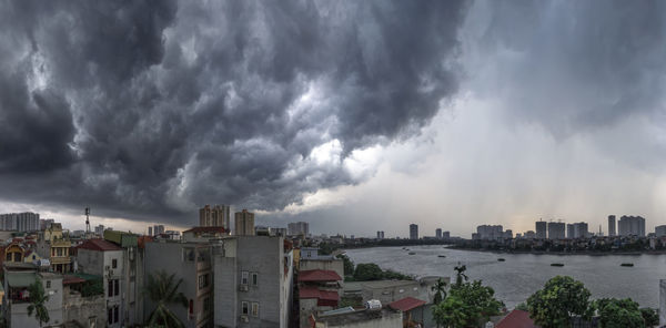 Panoramic view of buildings against cloudy sky