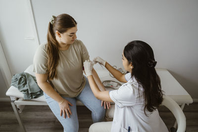 Doctor preparing female patient for medical exam at clinic