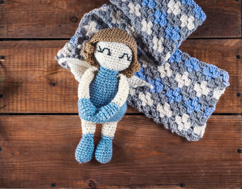 Knitted toy blue angel on a crocheted scarf
