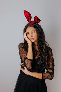 Portrait of beautiful woman standing against gray background