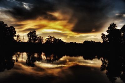 Reflection of trees in lake during sunset