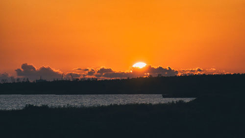 Scenic view of lake against romantic sky at sunset