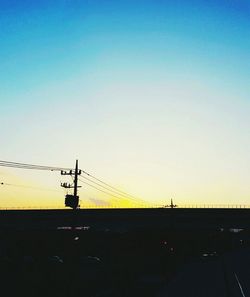 Silhouette bridge against clear sky during sunset