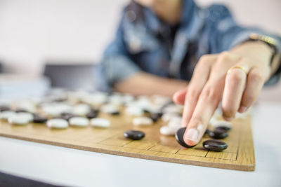 Midsection of man playing board game on table