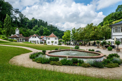 Houses by trees and buildings against sky