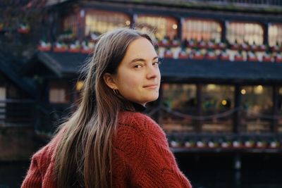 Portrait of young woman standing in city 