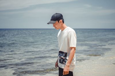 Full length of man standing on beach against sky